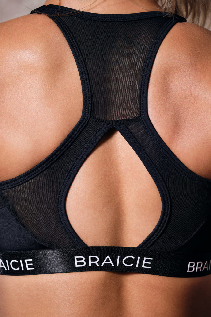 Detaillierte Rückenansicht einer Frau im BRAICIE Elegance Sport-BH in schwarz